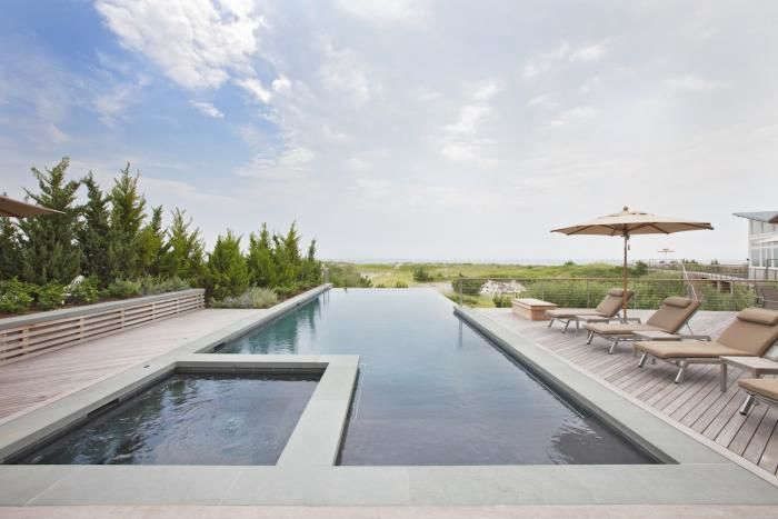 Infinity Pools o Piscinas Infinitas, todo lo que necesitas saber 2 En un jardín diseñado por Edmund Hollander, una piscina infinita de estilo Gatsby moderno se extiende hasta el horizonte y tiene un discreto borde de remate. Para saber más, consulta Lectura obligatoria: El Oasis Privado.